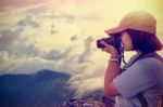 Vintage Style Hiker Taking Photo At Sunset Stock Photo