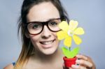 Beautiful Young Woman Showing One Artificial Daisy Stock Photo