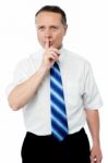 Business Man With Finger On Lips Asking For Silence Stock Photo