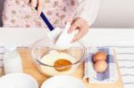 Woman Baking And Pouring Honey Into Milk Stock Photo