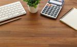 Calculator And Computer Keyboard On Wooden Table Stock Photo