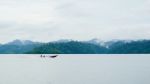 Landscape With Long Tail Boat Drive On Dam And Mountain Backgroud Stock Photo