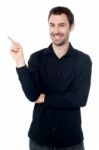 Casual Young Man Pointing Away Stock Photo