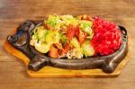 Sausage With Potatoes, Vegetables And Hot Sauce On A Plate Stock Photo