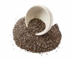 Chia Seeds Spilling Out From White Bowl Stock Photo