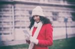 Beautiful Woman In Red Coat And Wool Cap And Gloves With Smartph Stock Photo