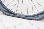 Bicycle Wheel With Flat Tyre On The Concrete Road Stock Photo