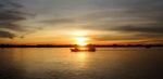 Boat Cruising At Sunset Stock Photo