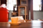 Orange Coffee Cup On Wooden Table Stock Photo