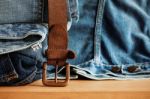 Old Belt And Jeans On Wooden Stock Photo