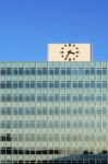 Clock On The Top Of Glass Building Stock Photo