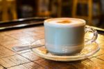 Coffee Cup With Milk Froth On Wooden Chess Table Stock Photo