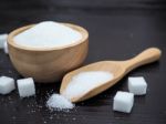 Wooden Bowl And Spoon With Sugar Cube On Dark Wood Background Stock Photo