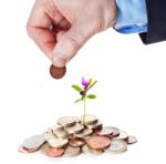 Hand Puts A Penny To A Heap Of British Coins Stock Photo