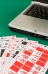 Bingo Cards On Casino Baize And A Laptop Stock Photo