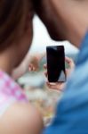 Young Couple Of Tourist In Town Using Mobile Phone Stock Photo