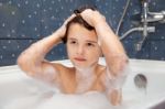 Little Girl Washes Her Head In The Bath Stock Photo