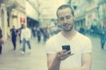 Young Man With Cell Phone Walking Stock Photo