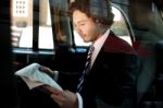 Man Reading Newspaper Inside Taxi Cab Stock Photo