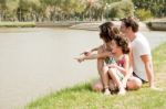 Family Sitting Near The Lake Stock Photo