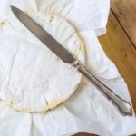 Camembert Cheese Wrapped In Paper With Vintage Knife On Wooden T Stock Photo