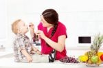 Mother Feeding Child With Grapes Stock Photo