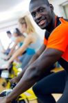 Young People With Fitness Bicycle In The Gym Stock Photo