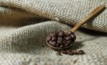 Coffee Beans In Wooden Spoon On Sackcloth Stock Photo