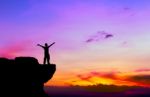 Silhouette Of A Man On The Rock At Sunset Stock Photo