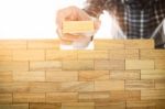 Hand Of Engineer Playing A Blocks Wood Tower Game (jenga) On Blu Stock Photo