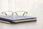 Glasses And A Book On The Desk Stock Photo