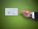 Hand Pointing To Switch Ofelectric Appliance On Green Wall Stock Photo