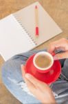 Woman In Torn Jeans Sitting At Coffee Shop Stock Photo