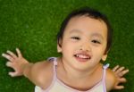 Young Child Sitting On Grass Stock Photo