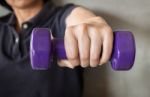 Woman Hand Holding Violet Dumbbell Stock Photo