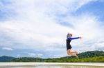 Happy Asian Teen Girl Jumping Fun On The Beach Stock Photo