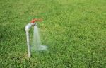 Tab Water Flowing Out From The Tab To Green Grass Field Stock Photo