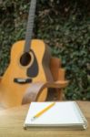 Yellow Acoustic Guitar On Wooden Table Stock Photo