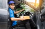 Delivery Messenger Man With Cardboard Box  Outside The Warehouse Stock Photo