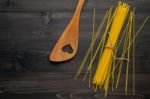 The Thin Spaghetti On Black Wooden Background. Yellow Italian Pa Stock Photo