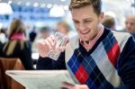 Young Man Reading Newspaper At Cafe Stock Photo