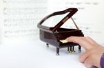 Fingers Playing On Small Model Of Grand Piano Stock Photo