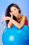 Women Behind Blue Pilates Ball Holding Bottle Of Water Stock Photo