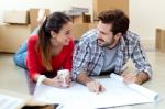 Young Couple Looking At The Blueprints Of Their New Home Stock Photo