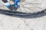 Bicycle Wheel With Flat Tyre On The Concrete Road Stock Photo