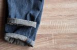 Close Up Of Fold Selvedge Denim Jeans On Wooden Background With Stock Photo