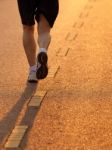 Feet Of Runner In Evening Light Stock Photo