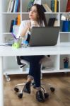 Pretty Young Woman Working With Laptop In Her Office Stock Photo