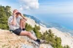 Dutch Man Sitting In Mountains Looking Through Binoculars Stock Photo