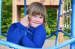 Young Girl Hanging In Web Of Blue Ropes Stock Photo